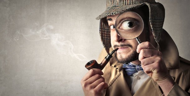 Silly detective with large magnifying glass, hat, and pipe