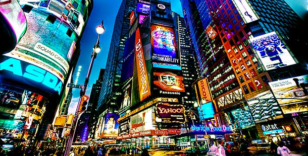 A picture of times square with brightly lit advertisements.