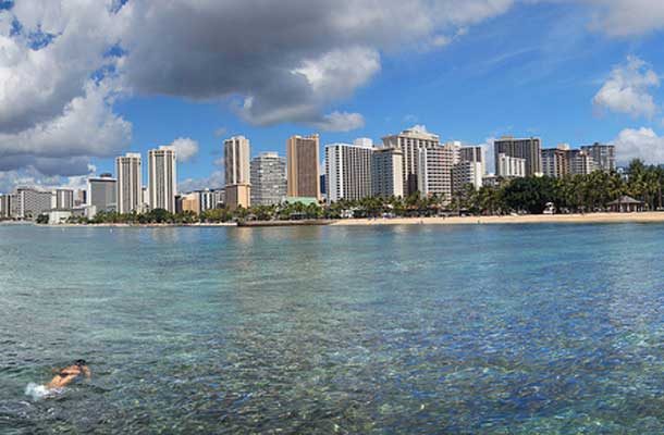 Waikiki beach from the water with a swimmer to the far left