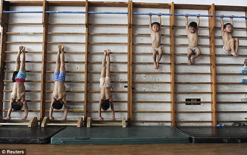 Chinese gymnast kids hanging on bars