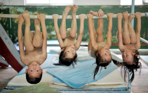 Young Chinese gymnasts hanging upside down