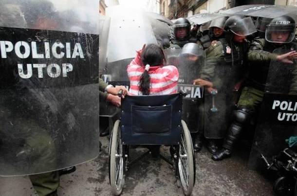 A lady in a wheelchair stands against the police in Bolivia