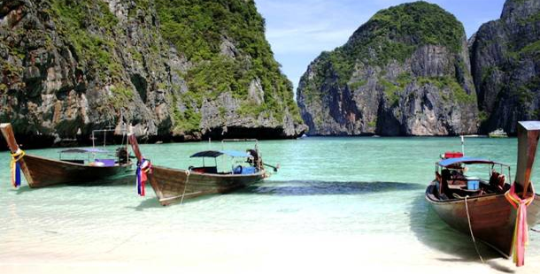 A boat in the water with phi phi islands in the background