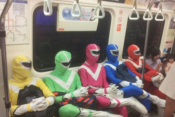 five people dressed as power rangers sit in a row