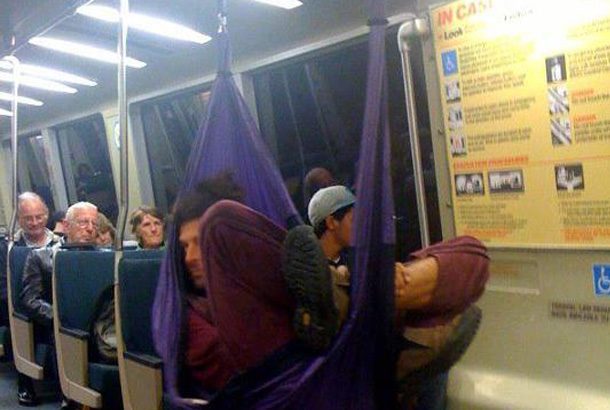 man lays in purple hammock