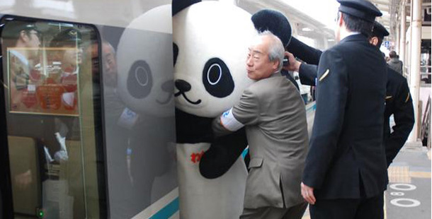 man pushes large panda onto subway