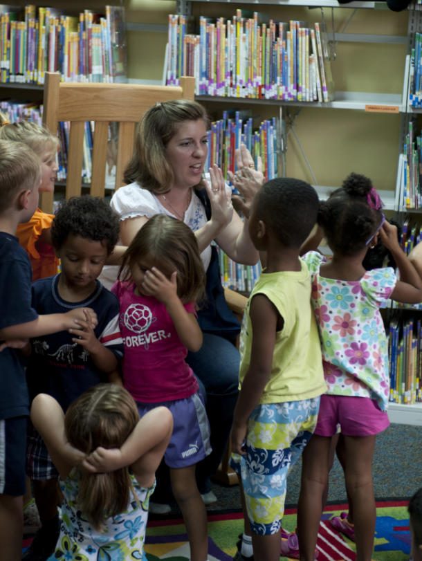 teacher interacting with kids at library
