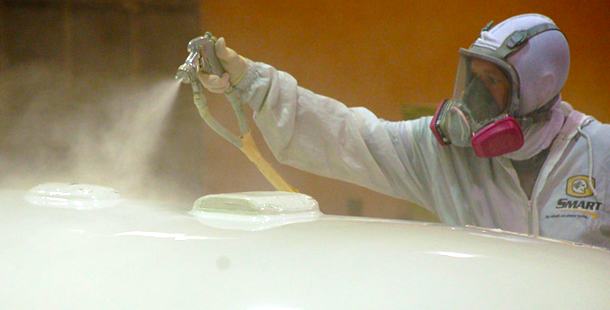 A person spraying a white object with a spray gun