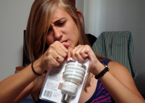 frustrated woman trying to open clamshell package