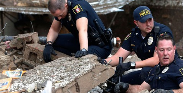 A group of police officers rescue on a broken concrete block