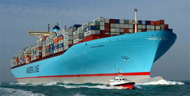 A large container ship with a tugboat