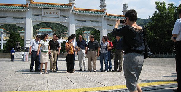 A group of tourists lining up to have their picture taken