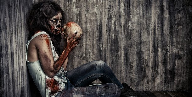 Zombie girl in corner eating skull