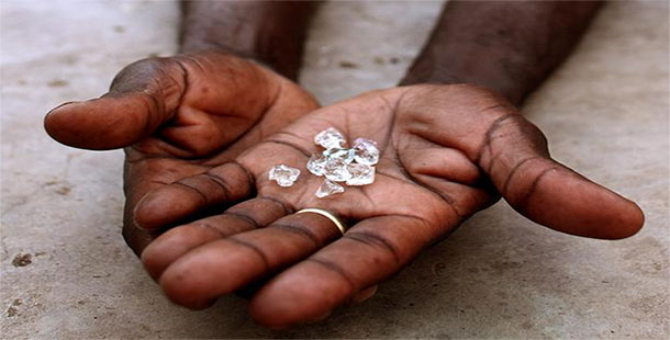 A close-up of a person holding a handful of diamonds