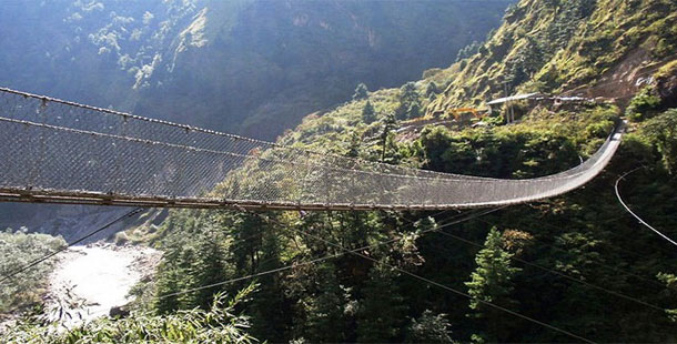 A person crossing a bridge over a valley