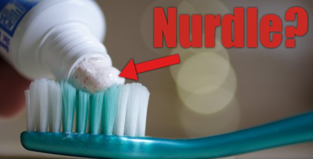 a peasize amount of toothpaste on toothbrush with the word "nurdle" and an arrow pointing to toothpaste