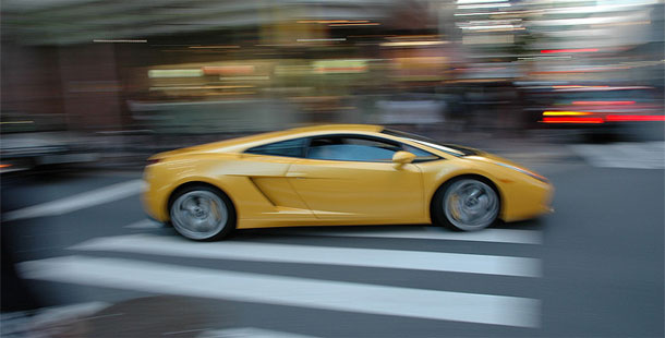 A fastest yellow sports car on a street
