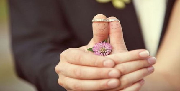 A wedding couple of fingers with a face drawn on them