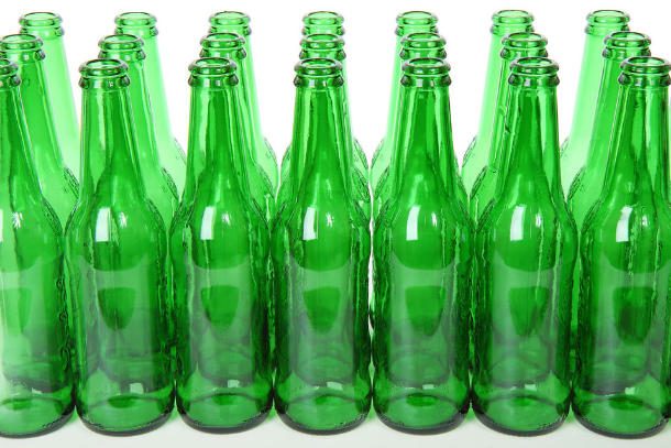 a bunch of green glass bottles lined up