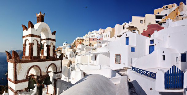 A white buildings with blue sky with santorini in the background, modern greece
