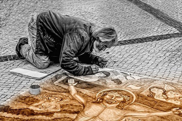 man painting jesus figure on street art