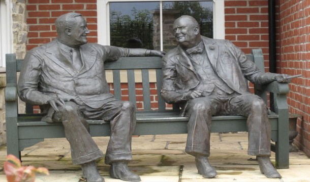 Two statues on a bench