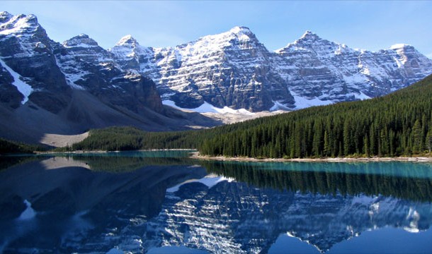 Marveling at the Rocky Mountains as they are reflected in Lake Moraine, Canada