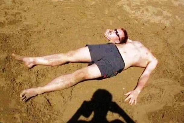 headless man on beach