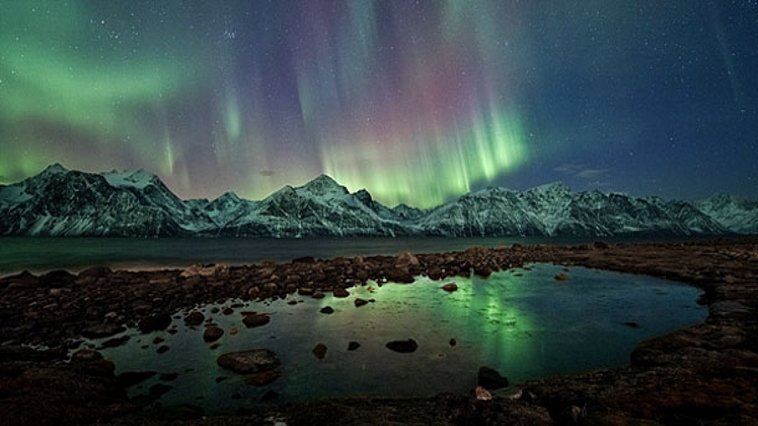 A northern lights in the sky over a body of water