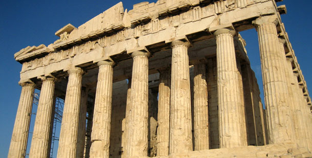 A close-up of a stone building with parthenon in the background