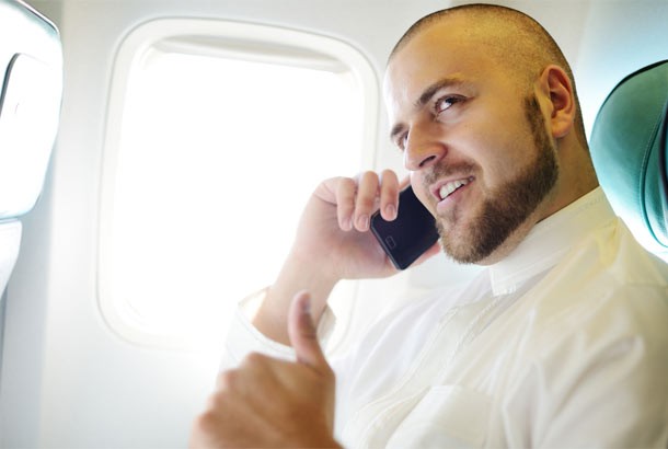 Man using phone on airplane