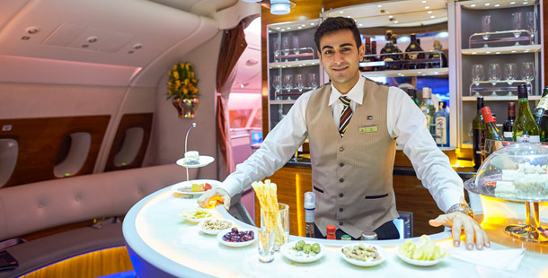 A person standing behind a counter of the most luxurious airlines with food on it