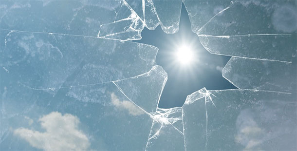 A sun shining through a broken glass