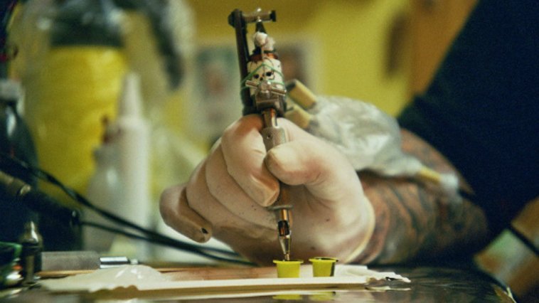 A person holding a tattoo machine