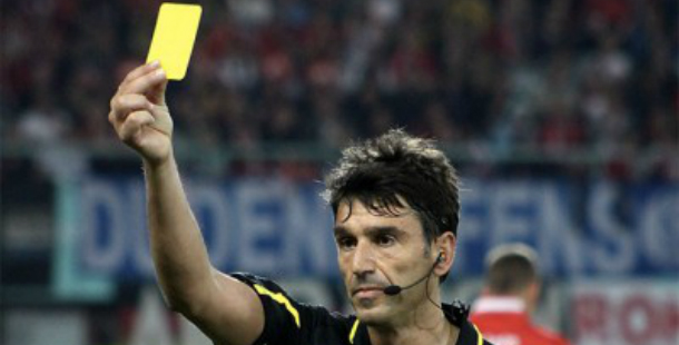 A person holding a yellow card with controversial sports rule