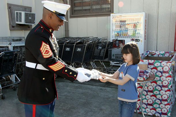 US_Navy_041205-N-1113S-005_A_seven-year-old_gives_an_electronic_toy_game_to_a_Marine_Corps_Gunnery_Sgt