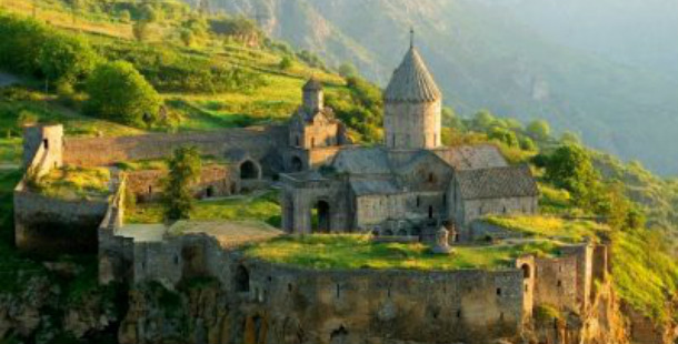 A stone building on a hill with tatev monastery in the background