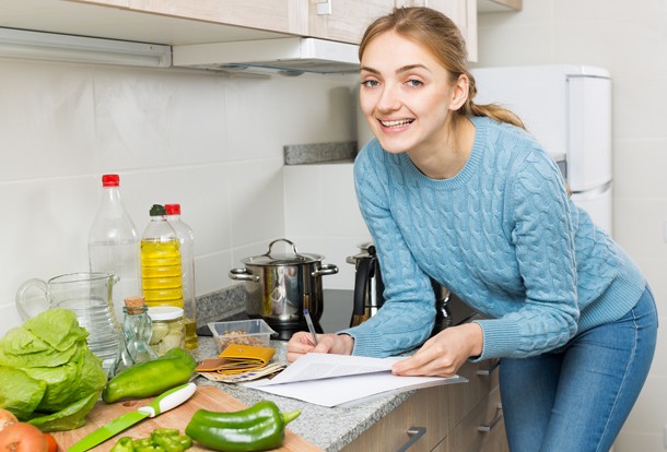 Young wife making list for cooking