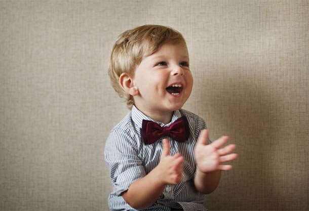 Clapping child with bow tie