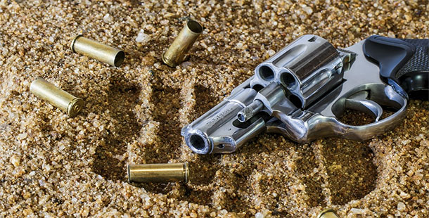 A gun with bullets on the ground