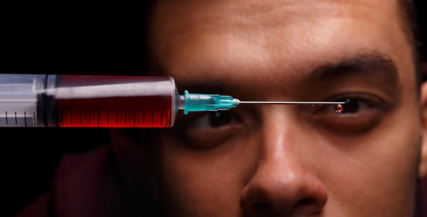 A close-up of a person's face with a syringe