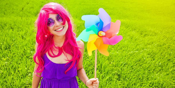 A person with pink hair holding a pinwheel