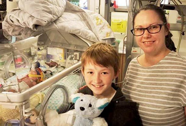 Campbell "Bumble" Remess stands next to mom with stuffed toy he created