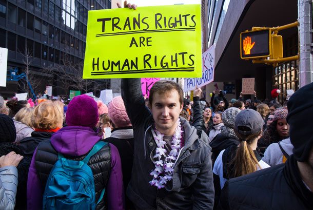 Man holding a trans rights sign