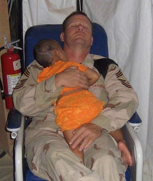 Chief Master Sgt. John Gebhardt comforts little girl who lost most of her family