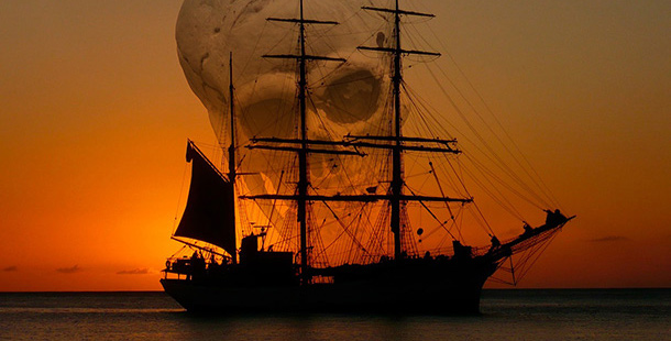 A ship in the water with a skull in the background
