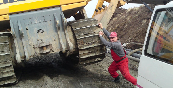 A person pushing a large piece of machinery