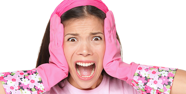 A person wearing pink gloves and holding her head