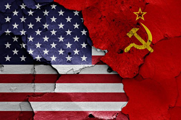US & soviet union flags together on cracked wall