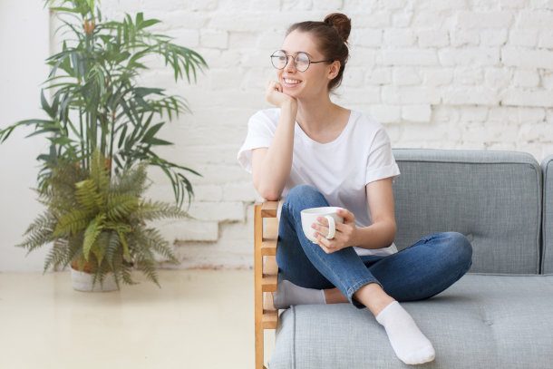 take a break - woman sitting on the couch with coffee